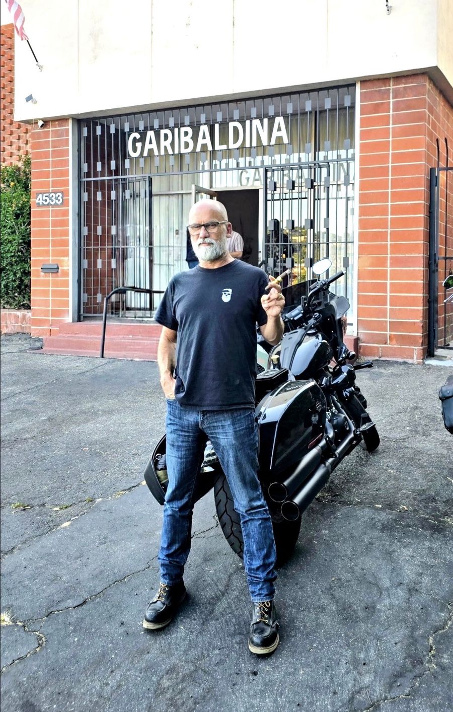 Dru Morgan, the Window Dude, standing in front of his motorcycle